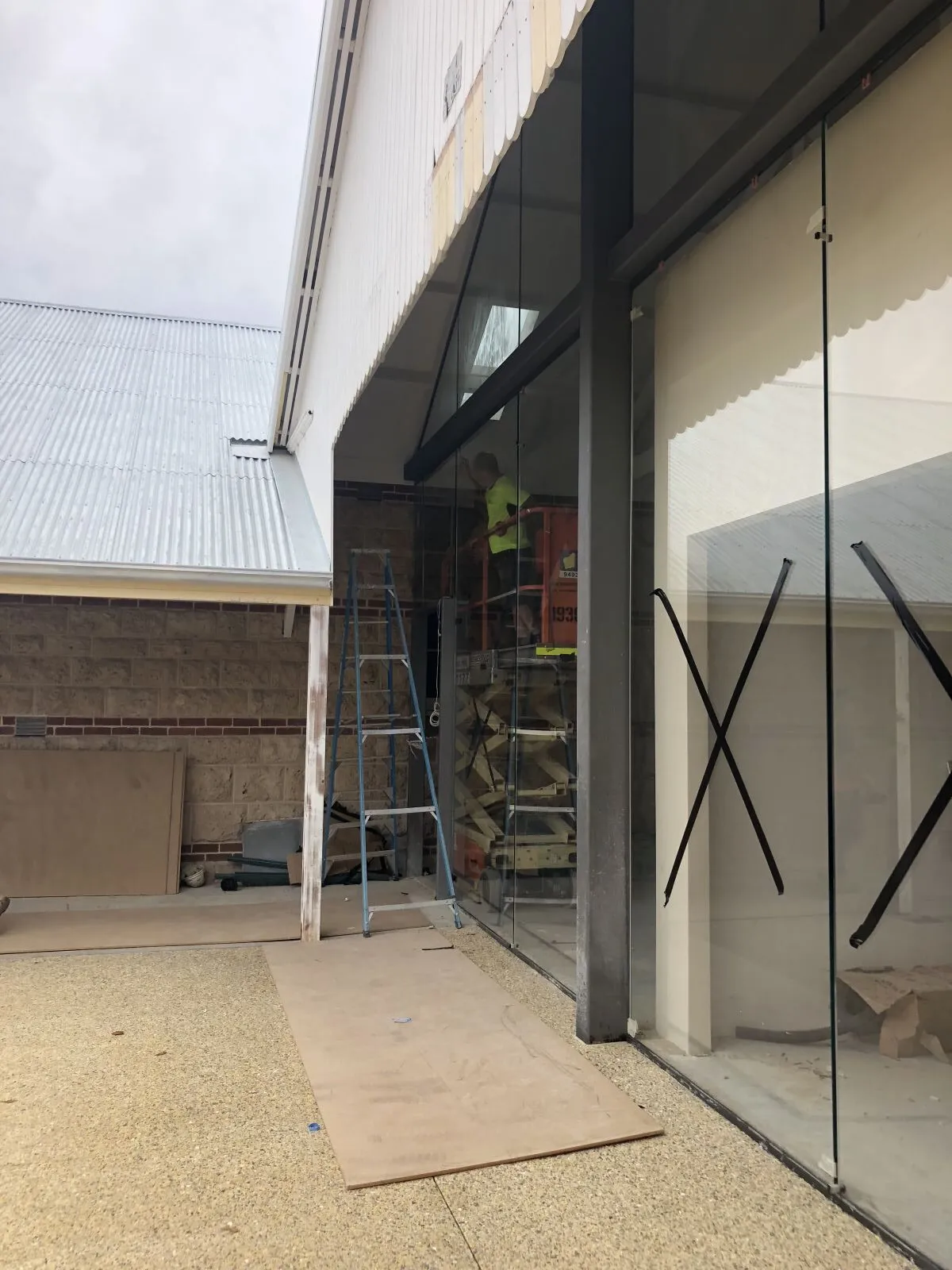 Tall glass wall with safety crosses under a verandah