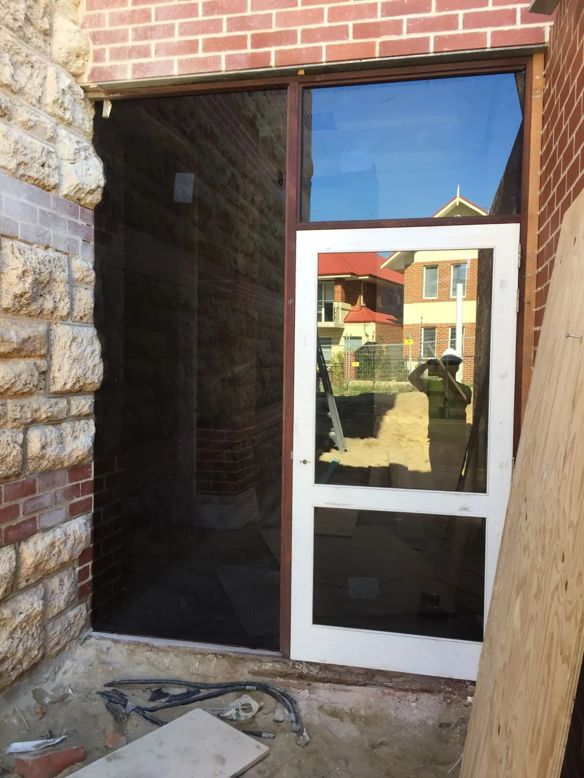 Framed glass door set into a brick and sandstone wall