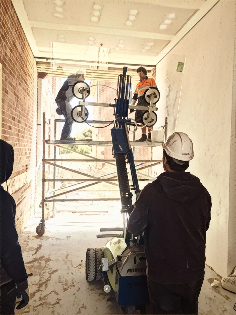 Glaziers lifting a large glass panel indoors