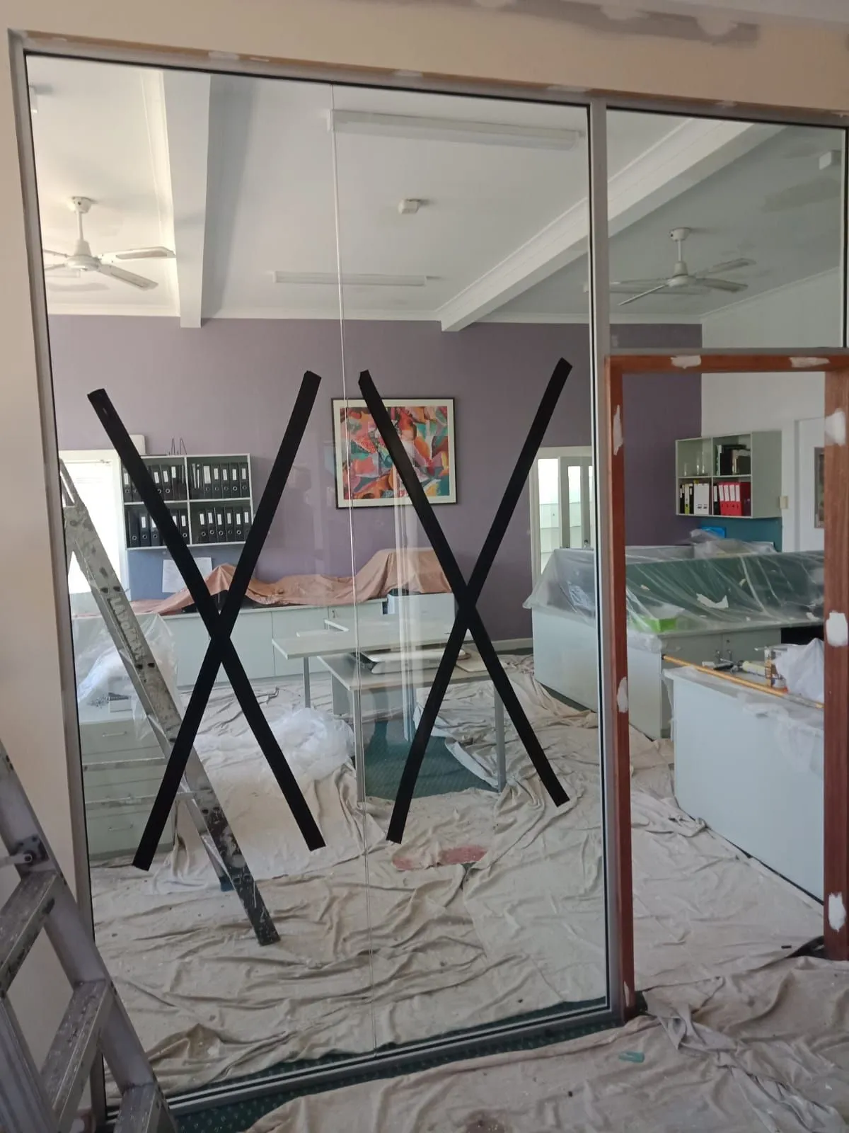 Framed glass partitions with safety crosses on a building site